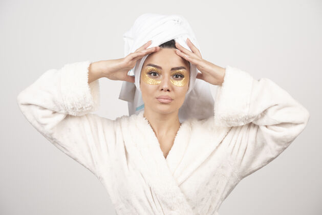 淋浴一个美丽的女孩戴着水凝胶眼罩的画像眼睛浴袍穿着
