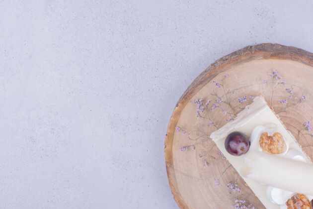 平铺一片核桃和葡萄放在木板上的蛋糕糕点咖啡馆极简