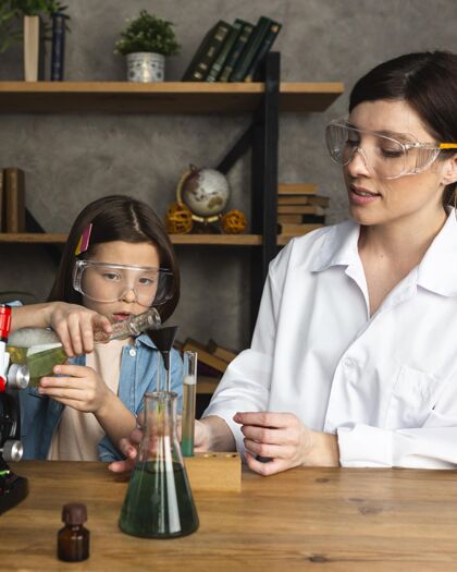 女人女孩和老师用试管做科学实验孩子科学家显微镜