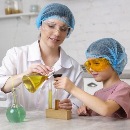 科学女老师和戴着发网的女孩用试管做科学实验眼镜研究员老师