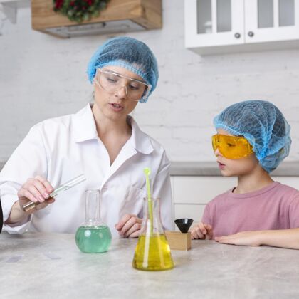 测试女老师和戴着发网的女孩在做科学实验安全眼镜研究员试管