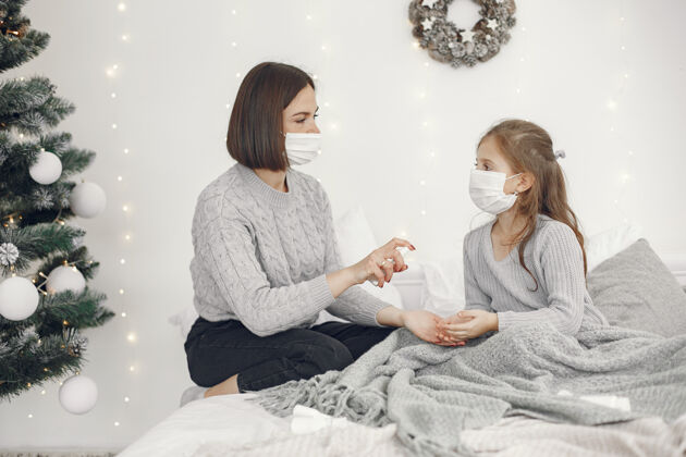 病毒儿童中有冠状病毒母亲带着女儿孩子躺在床上戴着医用口罩的妇女父母疾病床