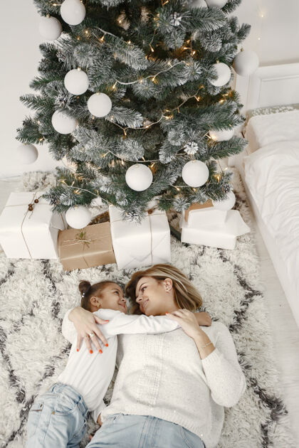 小人们在为圣诞节做准备母亲在和女儿玩耍一家人在节日的房间里休息孩子穿着毛衣女儿国际给予