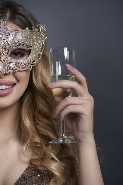 服装一个戴着面具的女人在干杯酒精化妆面具肖像