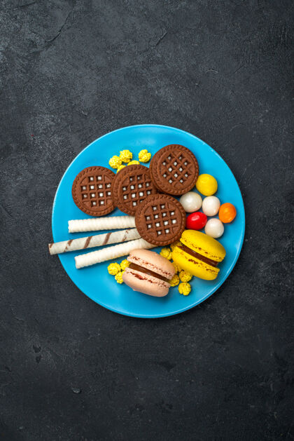 视图顶远眺美味的法国马卡龙糖果和巧克力饼干在深灰色表面饼干糖蛋糕甜烤饼干麦卡龙生的饼干