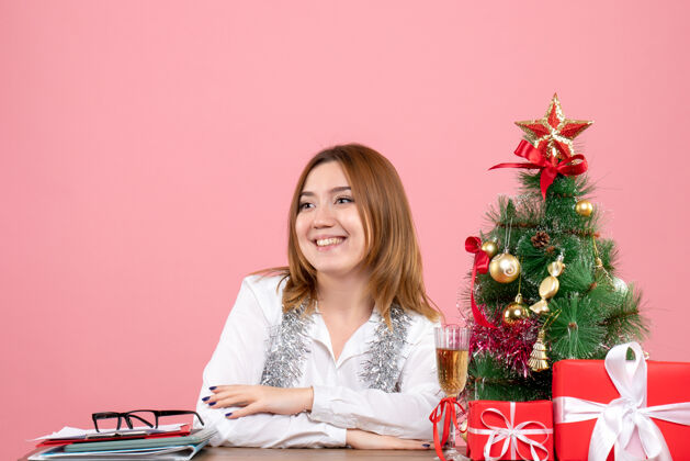 工作女工围坐在粉色的圣诞礼物旁的正视图笔记本电脑女工电脑