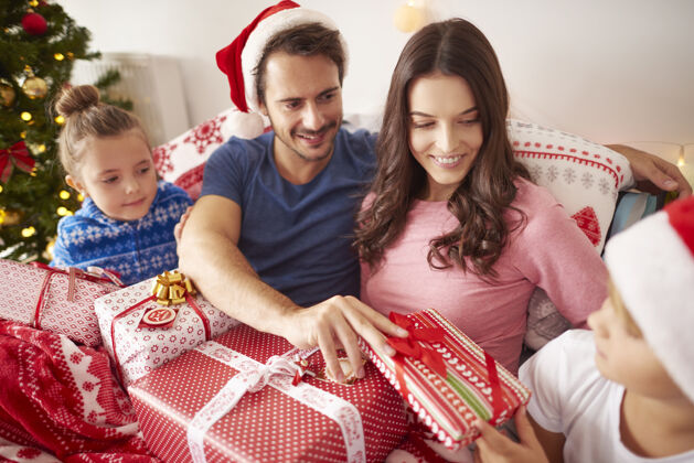 卧室家人分享圣诞礼物睡衣礼品盒坐着