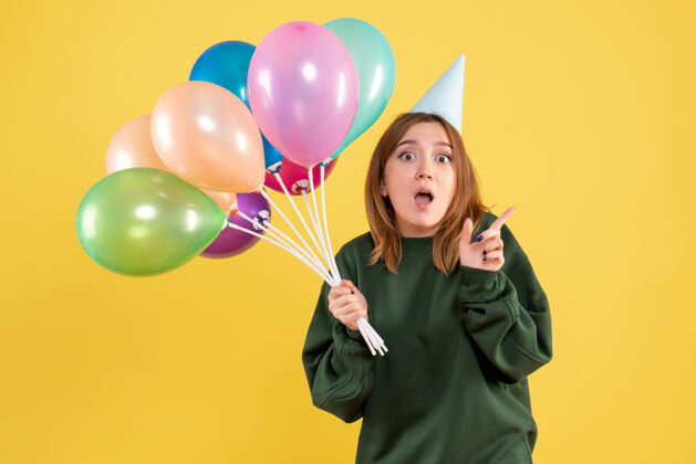 女性正面图：带着彩色气球的年轻女性幸福五颜六色气球