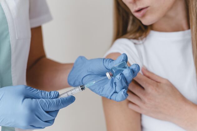 解药戴着手套的医生在为一个女人准备疫苗药品注射器免疫