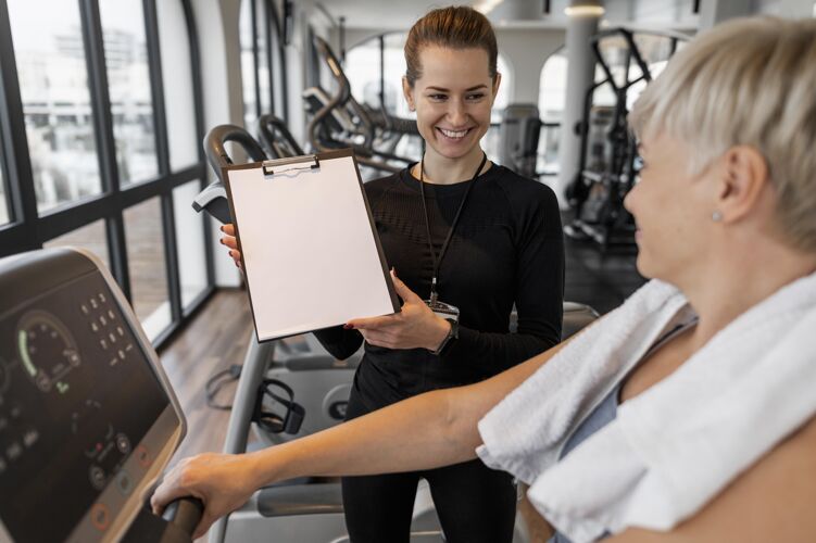 锻炼训练计划培训师和客户展示剪贴板教练健康运动
