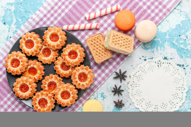 鸡蛋俯瞰美味的小饼干与橘子果酱麦卡龙和华夫饼上的蓝色办公桌饼干饼干甜甜的糖色茶水果华夫饼饼干