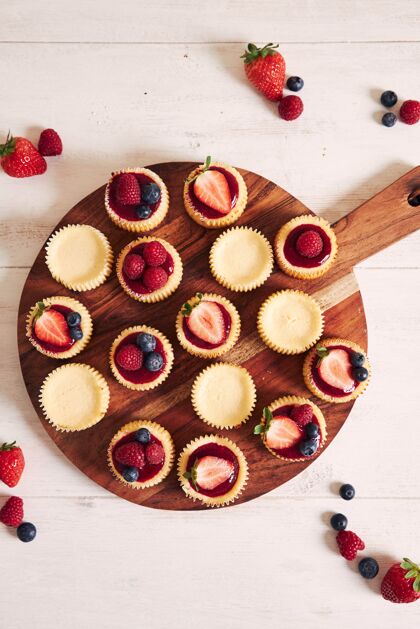 烘焙高角度拍摄的奶酪蛋糕与水果果冻和水果在一个木制的盘子浆果请客传统