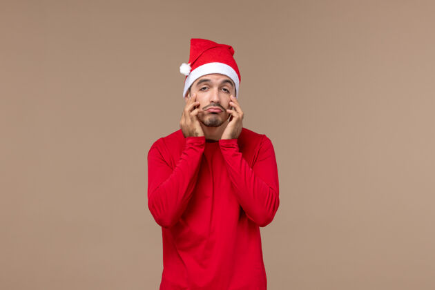 男人正面图棕色背景上表情悲伤的年轻男性节日圣诞感慨男性悲伤成人