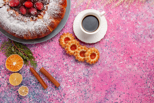 茶俯瞰美味的草莓蛋糕 配上饼干和一杯茶 背景是粉色蛋糕 烘烤甜甜的糖饼干 饼干 彩色馅饼蛋糕早餐视图