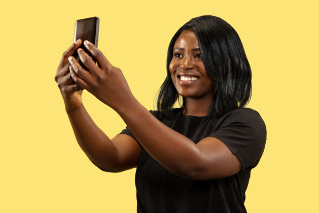 女性年轻的非洲女人隔离在黄色的工作室背景下 面部表情微笑女士肖像