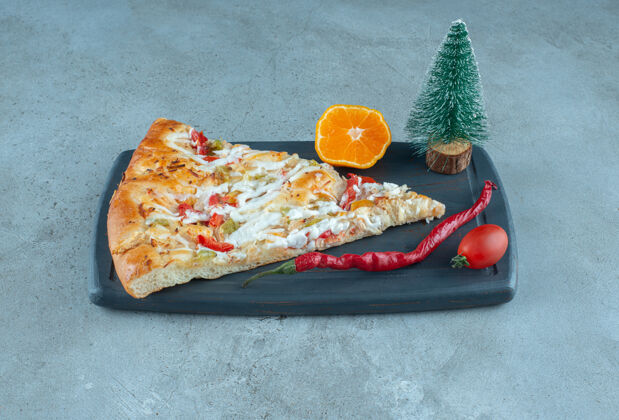 美味一块比萨饼放在木板上 大理石表面有一个树雕像美味可口披萨