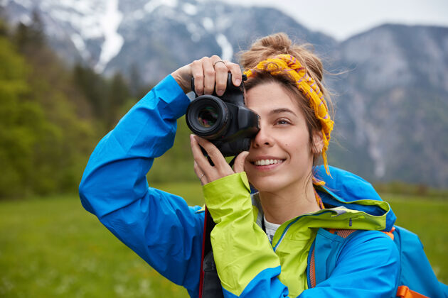 摄影快乐的欧洲年轻女子在徒步旅行中拍照 手持专业相机背包焦点山