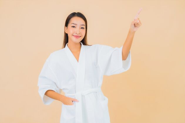 头部肖像美丽的亚洲年轻女子穿着米色的微笑浴袍浴室模特成人