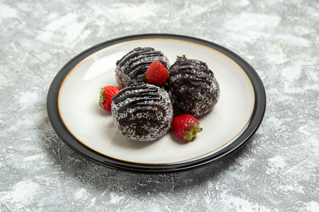 蓝莓正面图美味的巧克力蛋糕和新鲜的红色草莓在白色表面烘烤饼干糖蛋糕甜饼干巧克力可食用的水果生的黑莓