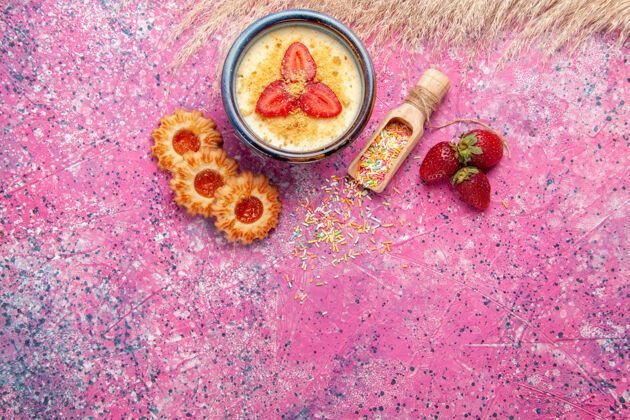 曲奇顶视图美味奶油甜点与红色切片草莓和小饼干浅粉色背景甜点冰淇淋浆果奶油甜水果蔬菜生的香料