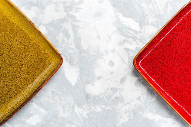 盒子顶部近距离观察空的方形盘子红色和橄榄色在白色表面盘子厨房食物照片餐具颜色正方形容器盘子