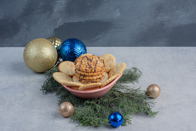 装饰放在碗里的饼干和饼干在大理石表面的圣诞装饰中可口松树甜点