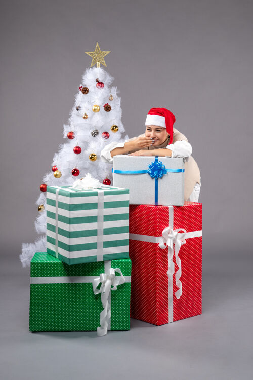 包漂亮的女孩在灰色的礼物周围盒子庆祝圣诞帽