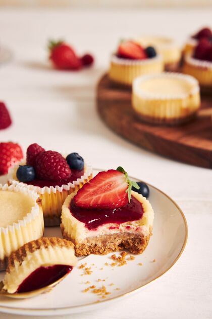 木板高角度拍摄的奶酪蛋糕与水果果冻和水果在一个木制的盘子勺子盘子桌子