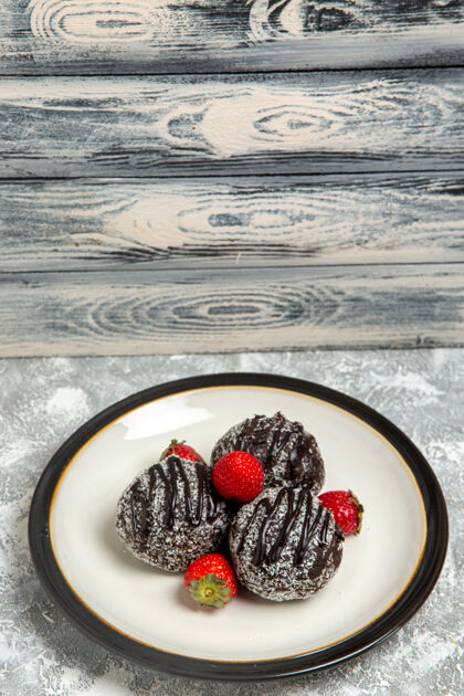 烘焙正面是美味的巧克力蛋糕 表面有新鲜的红色草莓 表面是浅白色的巧克力糖饼干 甜甜的蛋糕 烤饼干清淡饼干甜点
