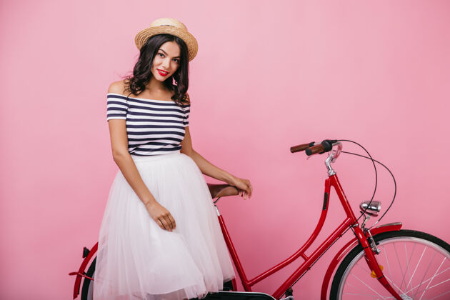 服装灵感来源于穿着长裙的欧洲女孩微笑着站在自行车旁优雅女模特摆姿势的室内镜头时尚优雅魅力