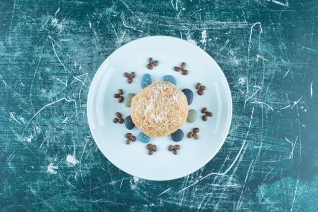 蛋糕松鼠蛋糕放在盘子里 蓝色的是糖果和咖啡豆糕点咖啡酿造