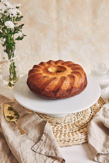 盘子美丽的镜头美味的环蛋糕放在一个白色的盘子和一个白色的花靠近它美味派奶油