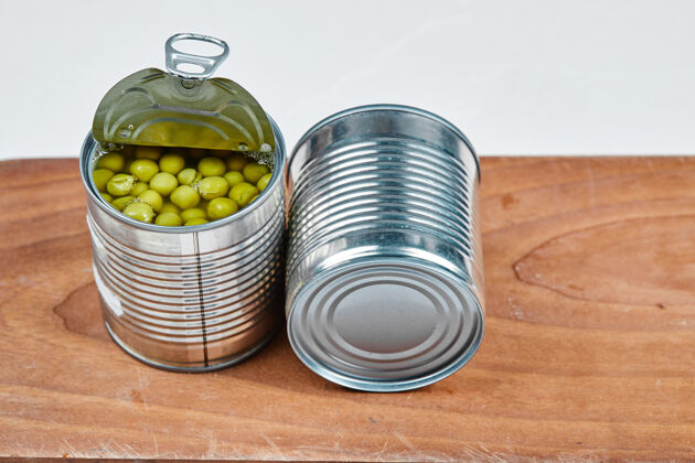 种子在木板上放两罐煮青豌豆食物美食全