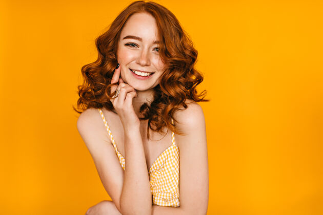 可爱兴奋的卷发女人的室内肖像 带着时髦的妆容姜黄色的白人年轻女士微笑着放松红发欧洲