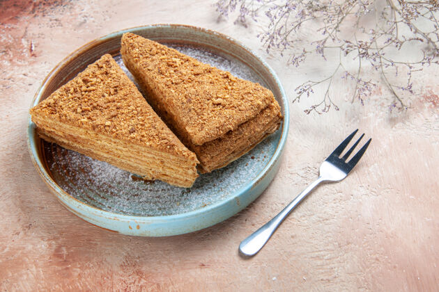 切片美味的蜂蜜蛋糕在灰色的托盘里甜食棕色托盘