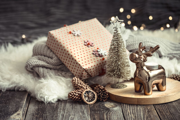 无人圣诞喜庆的背景与玩具鹿与礼品盒 模糊的背景与金色的灯光 喜庆的背景木制甲板桌和舒适的毛衣的背景问候欢乐季节