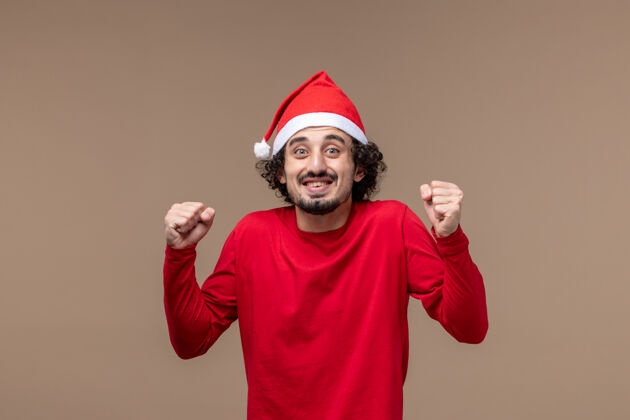 圣诞节正面图红色的男性在棕色背景上兴奋的表情节日情感圣诞节肖像快乐服装