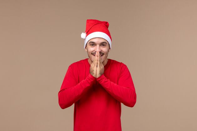 棕色正面图棕色背景圣诞情感假期 年轻男性喜气洋洋情感微笑微笑
