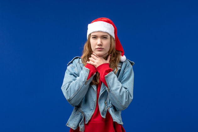 男性正面图蓝色背景上有喉咙痛的年轻女性圣诞情感色彩前面蓝色年轻女性