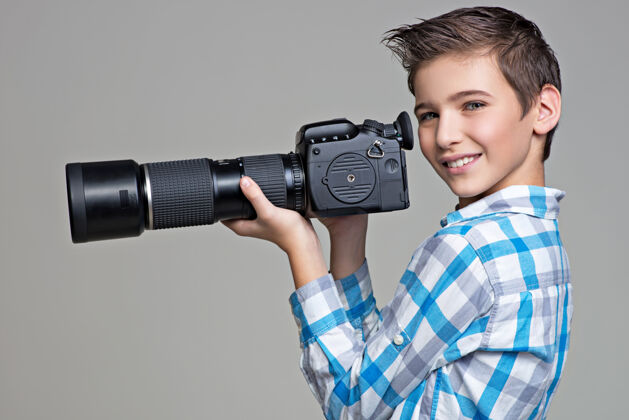 照片男孩拿着带远摄镜头的大照相机男孩图片背景