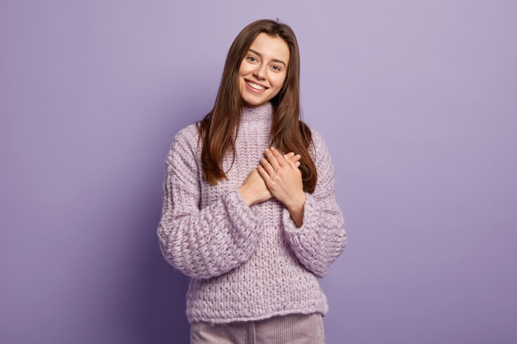 室内《幸福的欧洲年轻女子画像》双手放在胸前 展示心形 表达感激 感恩 模仿紫墙肢体语言单色人与奉献时尚毛衣感恩