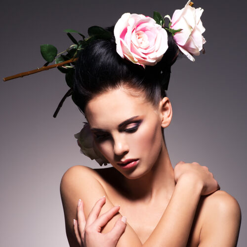 花美丽的年轻女子的肖像与鲜花在头发的姿势头发女性手