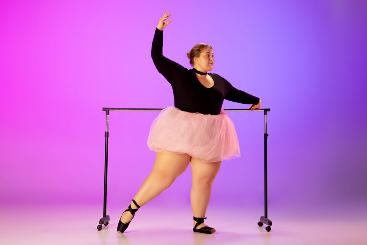 梦想美丽的高加索人模特在霓虹灯下的渐变紫粉色工作室背景上练习芭蕾舞激励 包容 梦想和成就的理念值得成为芭蕾舞演员舞者成功芭蕾舞