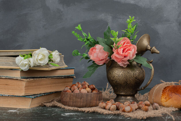 木制的在大理石桌上放着书和花瓶的坚果食物打开的面包房