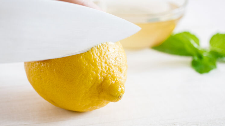 块用锋利的小刀在白色上切熟柠檬厨房自然生的