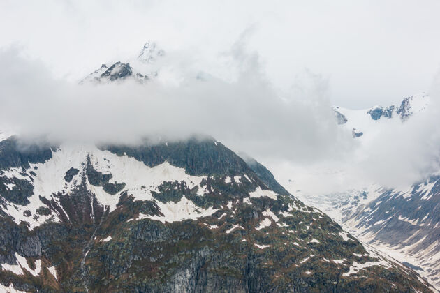 岩石夏季多云的阿尔卑斯山和贝特默霍恩山脊从大阿勒奇冰川和冰瀑（贝特默阿尔普 瑞士）流阿尔卑斯山冰川