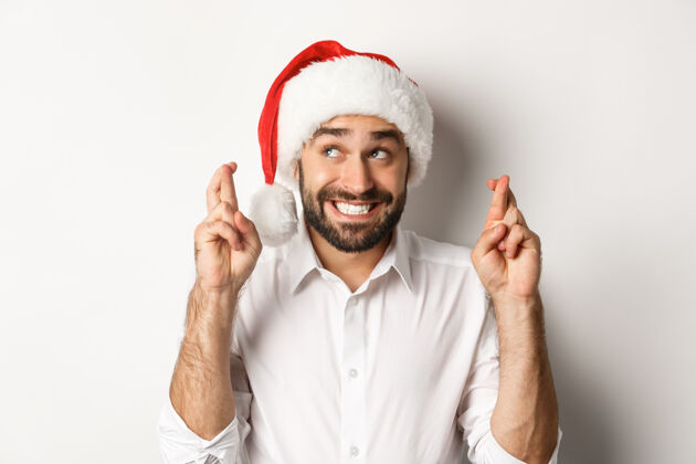 情绪化派对 寒假和庆祝概念戴圣诞帽的快乐男人许下圣诞愿望 祈祷好运 微笑着兴奋脸圣诞老人休闲