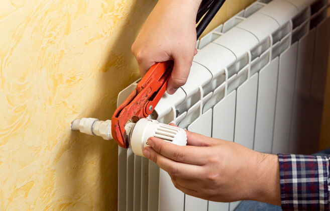 建筑安装散热器和连接阀的人的特写视图工匠暖气安装
