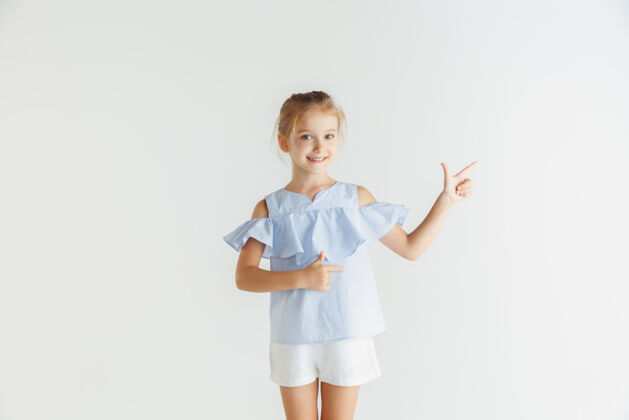 服装时尚的小女孩微笑着摆出休闲服装隔离在白色工作室漂亮自信活动