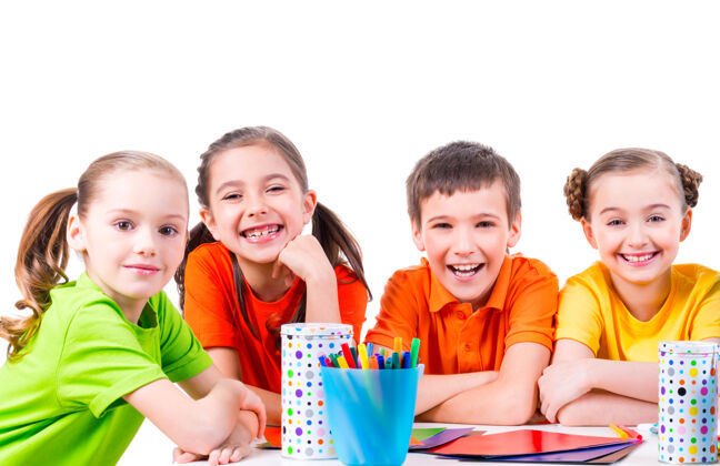 学校一群孩子坐在桌子旁 手里拿着记号笔 蜡笔和彩色纸板四同学漂亮